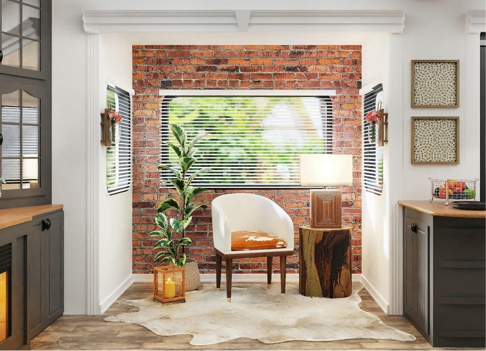 Cozy interior design featuring a white armchair with an orange accent pillow, a decorative wooden side table, and a potted plant, set against a rustic brick wall and natural light from a window, embodying functional and stylish home remodeling.