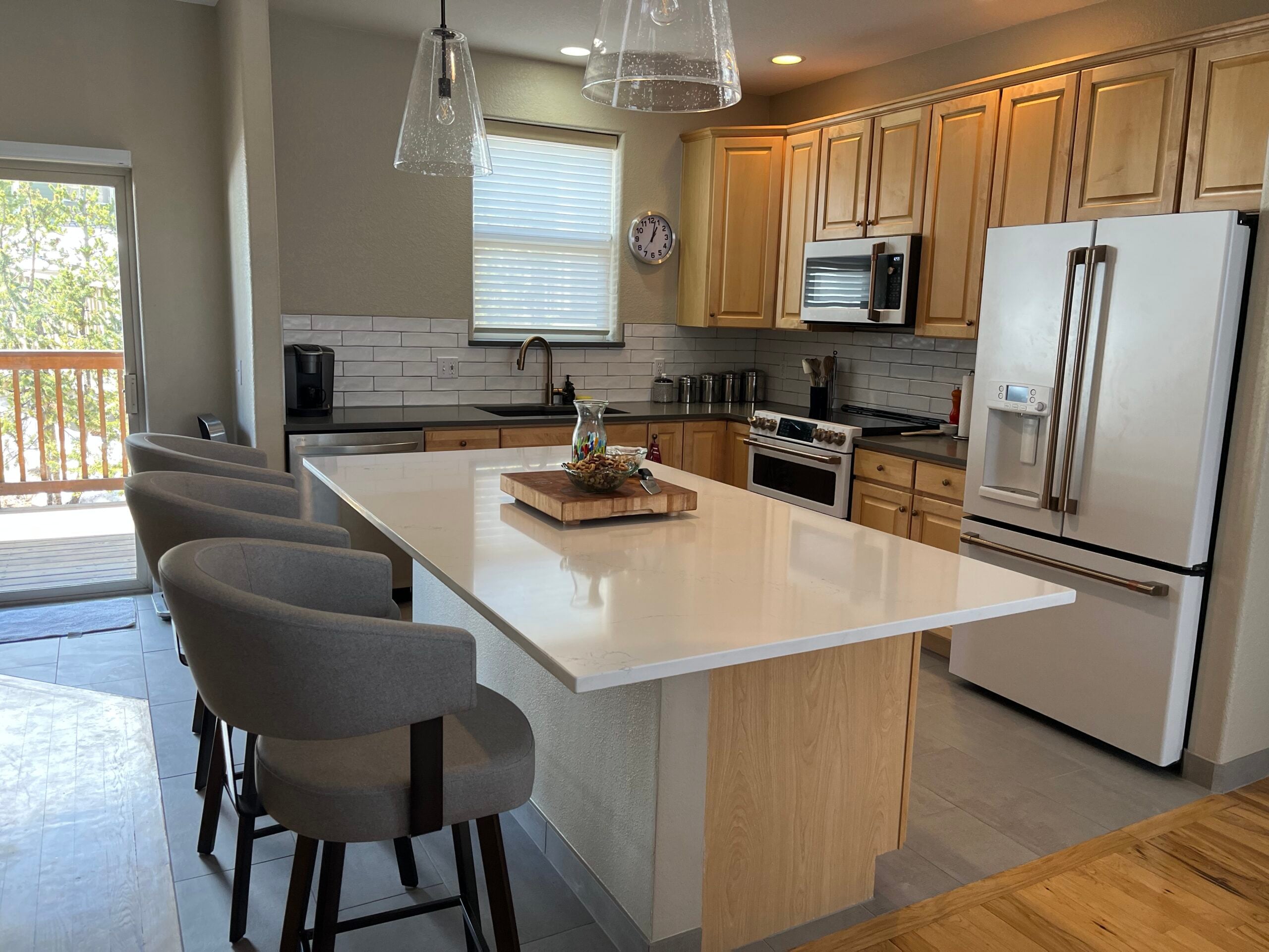 Modern kitchen design in Breckenridge featuring sleek cabinetry, stainless steel appliances, and a large island with seating, emphasizing a stylish and functional remodeling space.