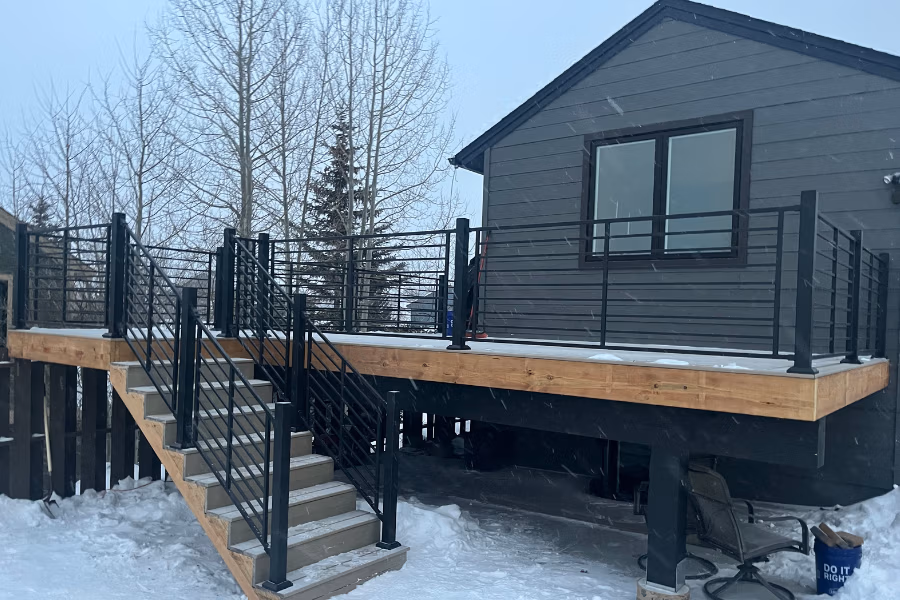 Deck with custom railing and stairs, surrounded by snow, showcasing quality construction for mountain living in Summit County, CO.